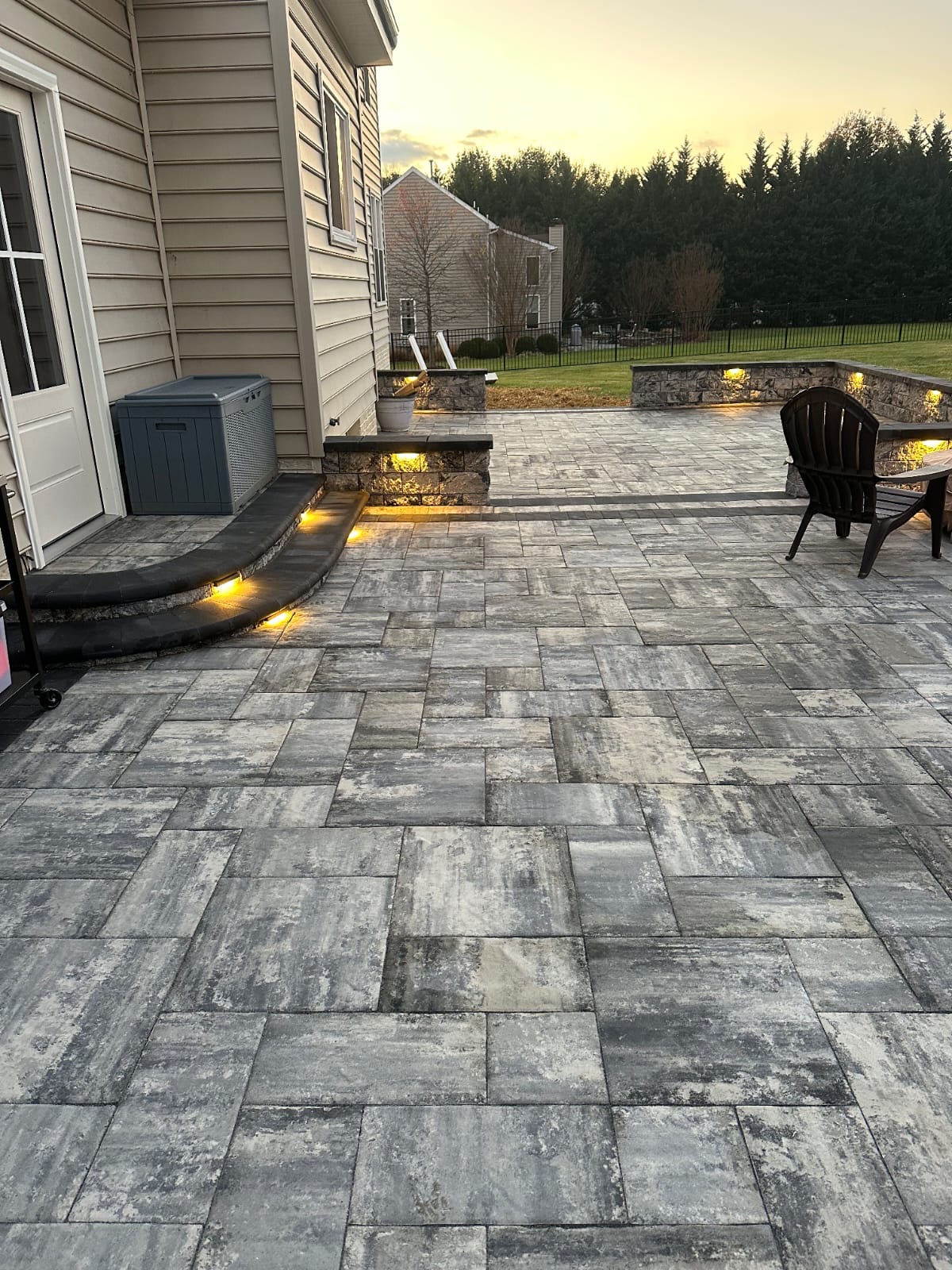 Paver patio with stacked-stone seating walls and integrated lighting