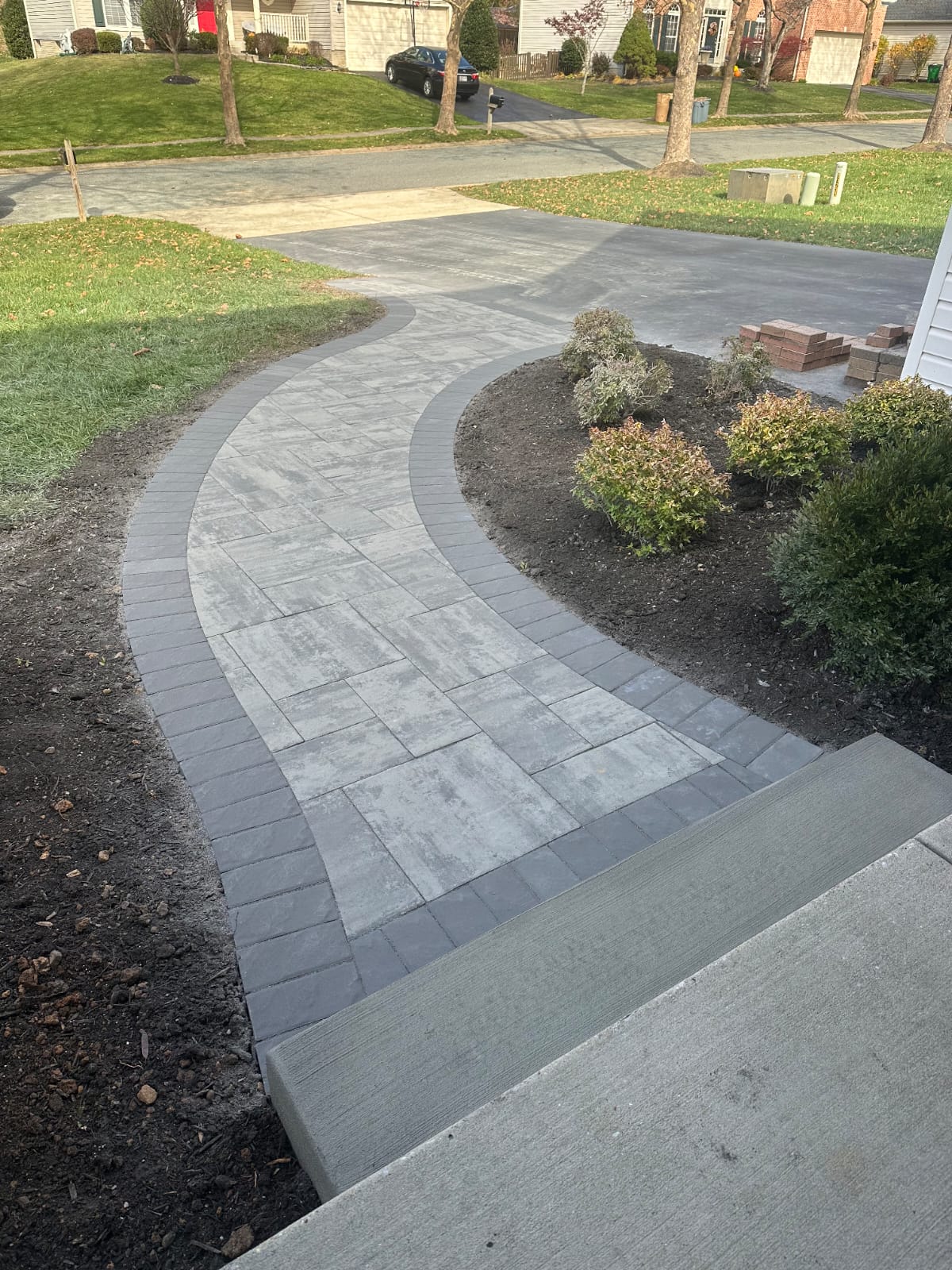 Curved paver walkway connecting the driveway to the front steps